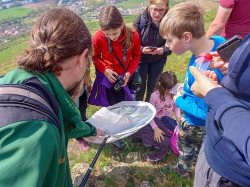 Obr. 3: Děti se dívají do síťky entomologa.  Foto Lucie Benešová